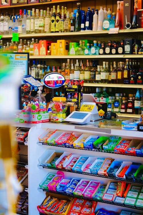 Free Colorful candy and liquor display in a store with a variety of sweets and beverages on shelves. Stock Photo