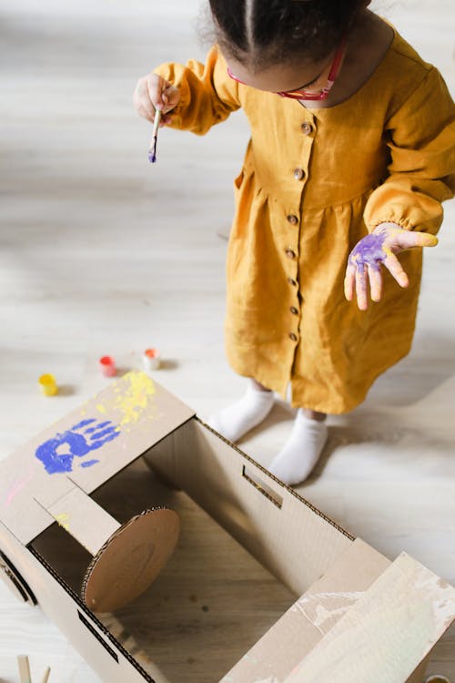 Free Girl in Yellow Dress Painting on Cardbaord Stock Photo