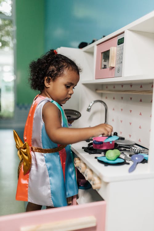 Free A Little Girl Playing with a Toy Kitchen Set  Stock Photo