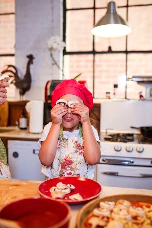 Free Woman in White Floral Shirt Holding Red Plastic Plate Stock Photo