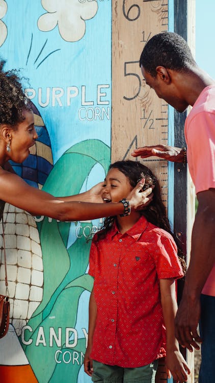 Free Parents Measuring their Child's Height Stock Photo