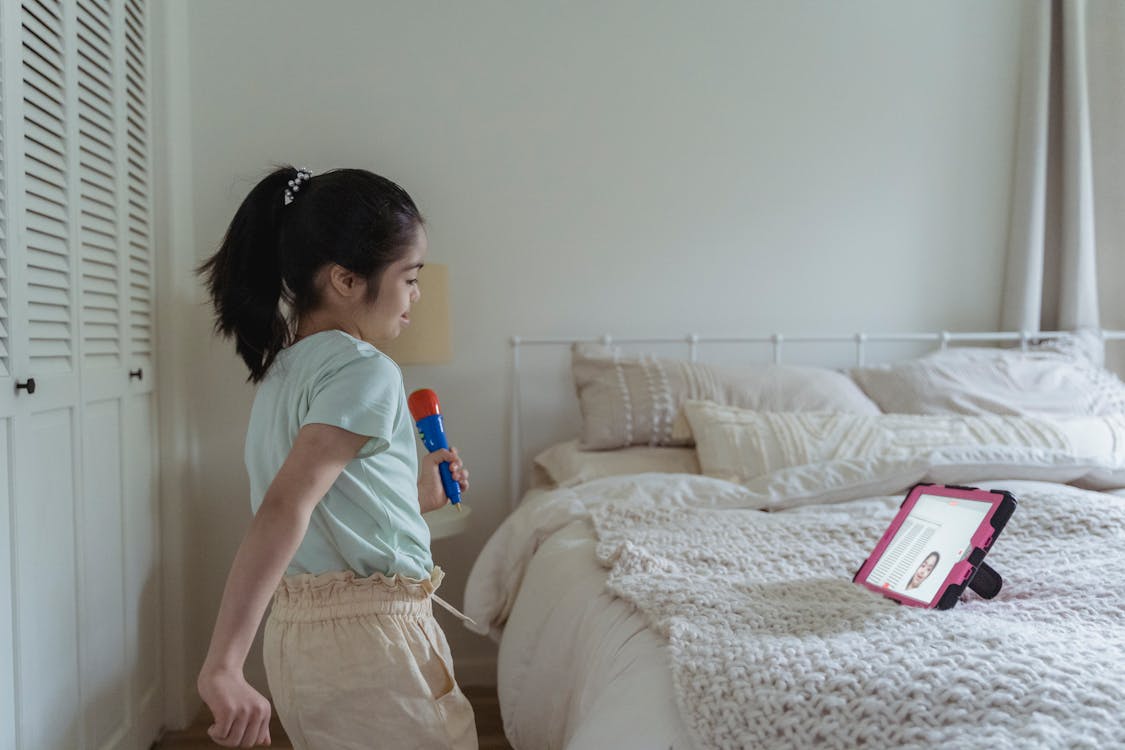 Free Girl in Green Shirt Standing beside the Bed Stock Photo