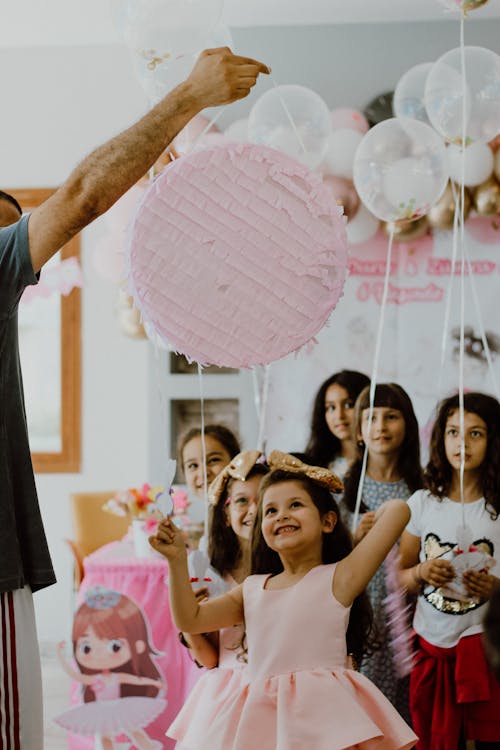 Free Man Holding a Pink Round Piñata Stock Photo