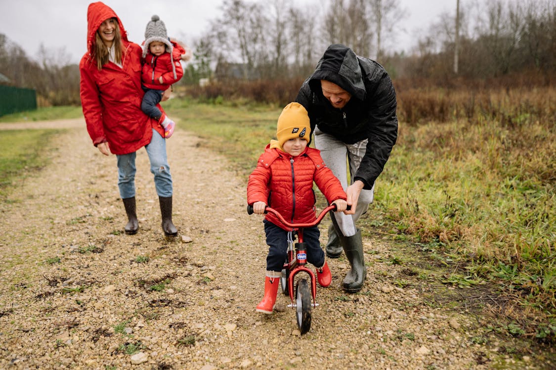 Free Man Teaching His Child How to Ride a Bicycle Stock Photo