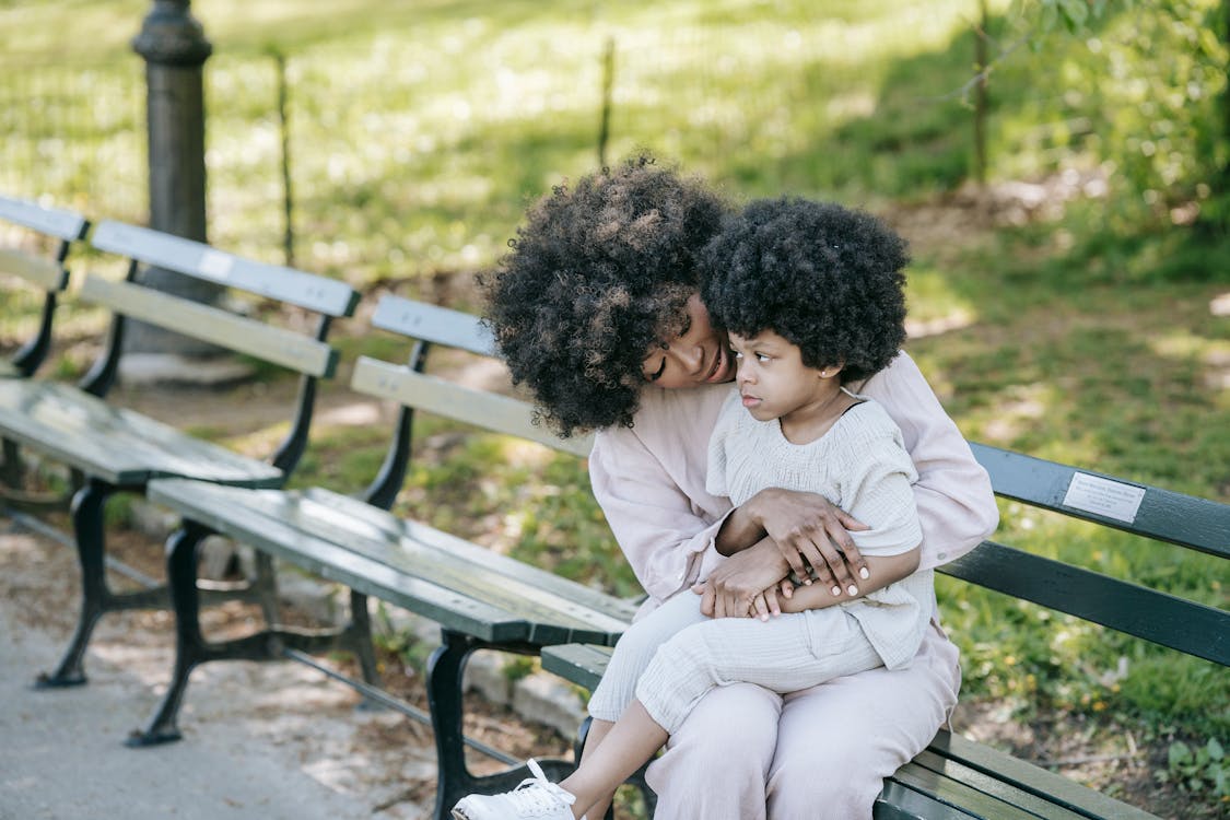 Free Curly Haired Girl Sitting on the Woman's Lap  Stock Photo