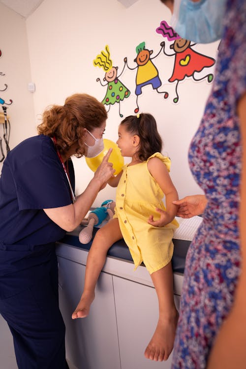 Free Nurse Talking to a Little Girl at a Pediatricians Office Stock Photo