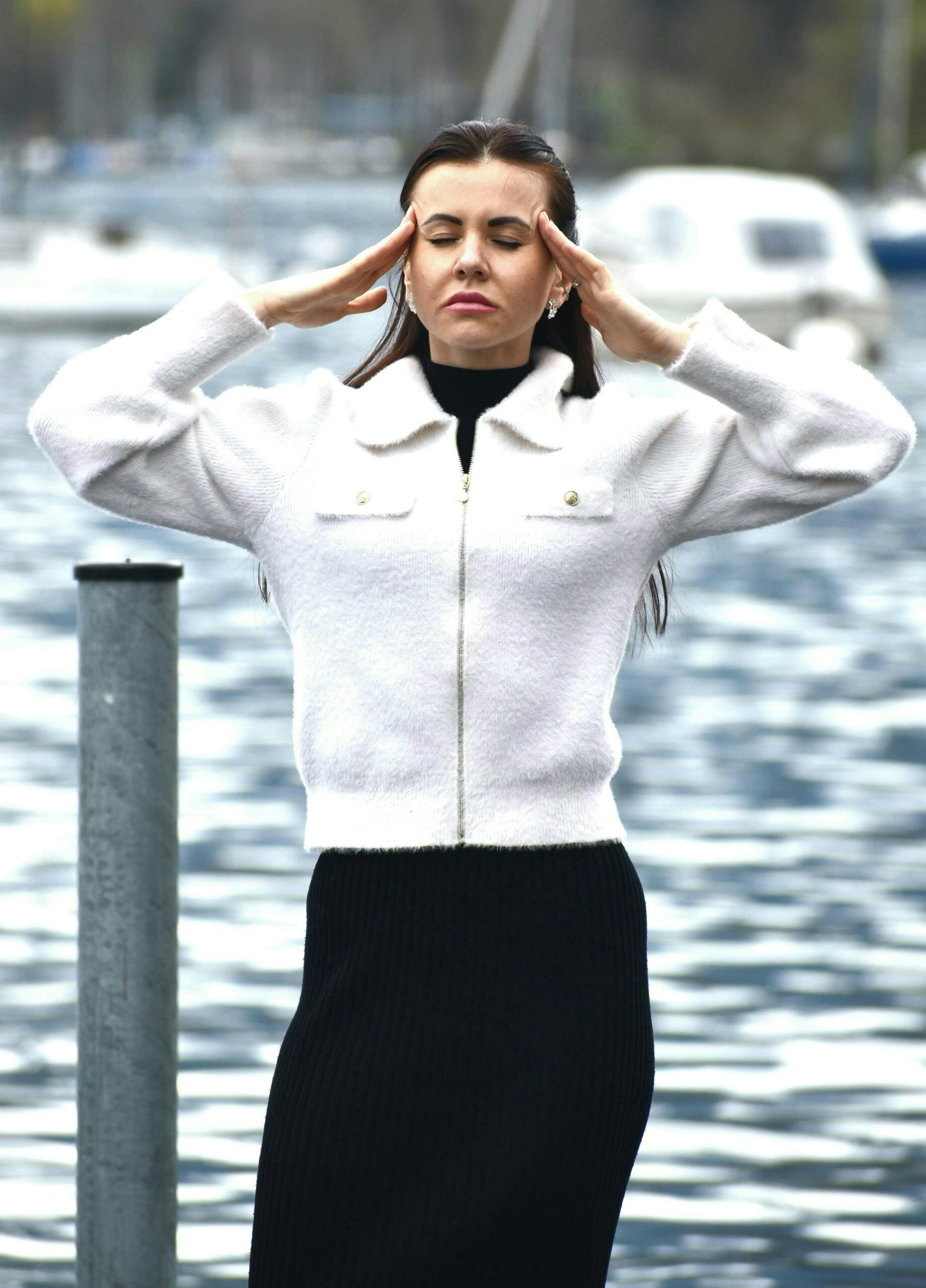 A woman in a white jacket and black skirt